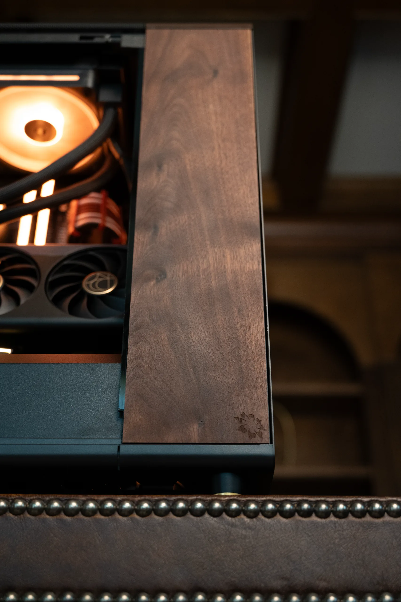 The walnut top cap, grain catching the glow from inside